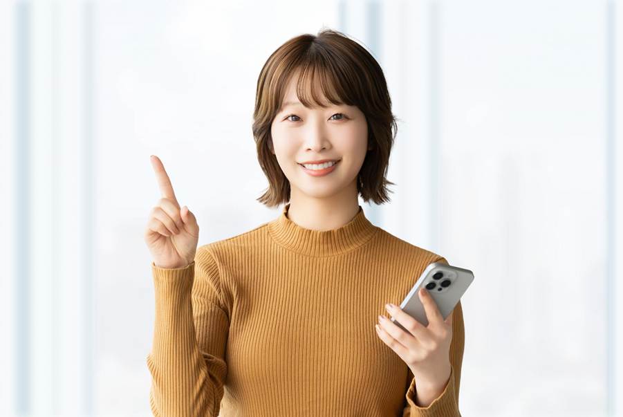 スマホ片手に指を立てて示唆する女性