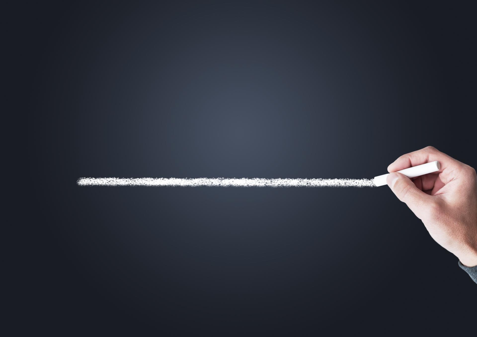 チョークで線引きする手