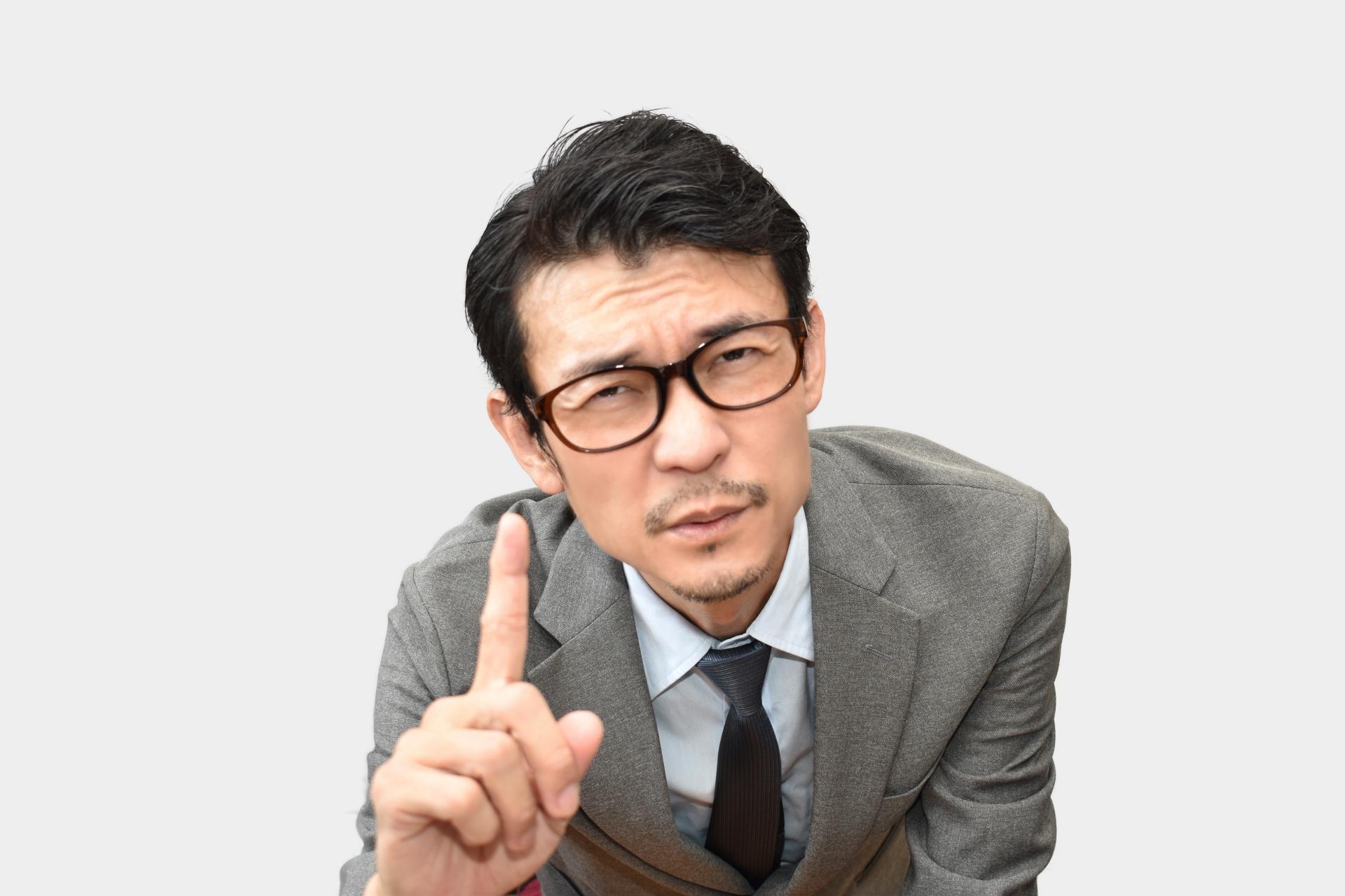 しぶい顔で指を立てる男性ビジネスマン